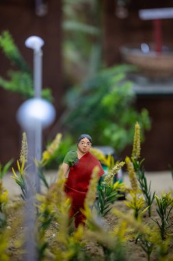Handmade idol of indian farmer while working in farming field made with clay. Selective focus. clipart