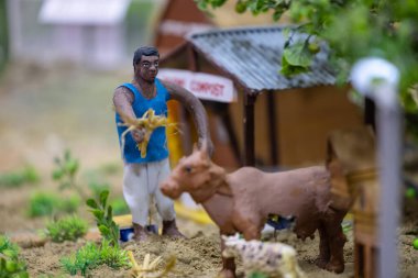 Handmade idol of indian farmer while working in farming field made with clay. Selective focus. clipart