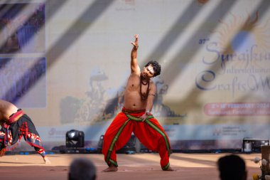 Faridabad, Haryana, Hindistan - 17 Şubat 2024: Güney Hintli erkek sanatçı surajkund sanatları fuarında klasik dans kuchipudi performansı sergiliyor.