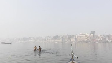 Varanasi, Uttar Pradesh, Hindistan - 05 Mart 2023: Eğlence için Ganj Nehri 'nde yüzen gençlerin görüntüleri.