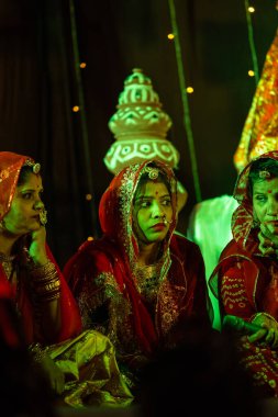 Bikaner, Rajasthan, Hindistan - 13 Ocak 2023: Geleneksel renkli rajashani kıyafetleri içinde güzel bir kadın grubu ve deve festivali sırasında sahnede kültürel gangaur pooja gösterisi.