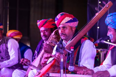 Bikaner, Rajasthan, Hindistan - 13 Ocak 2023: Deve Festivali, Rajasthani erkek sanatçı portresi Bikaner deve festivali sırasında geleneksel rajasthani elbisesi ve renkli türbanla sahnede.