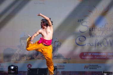 Faridabad, Haryana, Hindistan - 17 Şubat 2024: Güney Hintli erkek sanatçı surajkund sanatları fuarında klasik dans kuchipudi performansı sergiliyor.