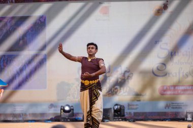 Faridabad, Haryana, Hindistan - 17 Şubat 2024: Güney Hintli erkek sanatçı surajkund sanatları fuarında klasik dans kuchipudi performansı sergiliyor.