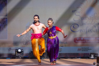 Faridabad, Haryana, Hindistan - 17 Şubat 2024: Güney Hintli erkek ve kadın sanatçı Surajkund sanatları fuarında klasik dans kuchipudi performansı sergiliyorlar.