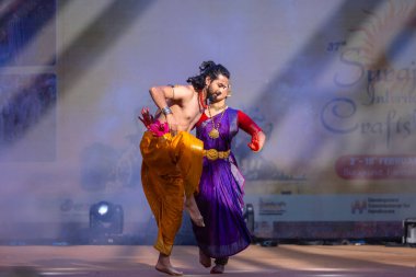 Faridabad, Haryana, Hindistan - 17 Şubat 2024: Güney Hintli erkek ve kadın sanatçı Surajkund sanatları fuarında klasik dans kuchipudi performansı sergiliyorlar.
