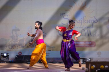 Faridabad, Haryana, Hindistan - 17 Şubat 2024: Güney Hintli erkek ve kadın sanatçı Surajkund sanatları fuarında klasik dans kuchipudi performansı sergiliyorlar.
