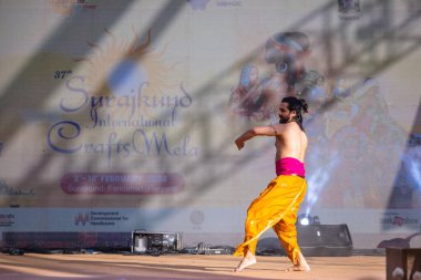 Faridabad, Haryana, Hindistan - 17 Şubat 2024: Güney Hintli erkek sanatçı surajkund sanatları fuarında klasik dans kuchipudi performansı sergiliyor.