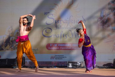 Faridabad, Haryana, Hindistan - 17 Şubat 2024: Güney Hintli erkek ve kadın sanatçı Surajkund sanatları fuarında klasik dans kuchipudi performansı sergiliyorlar.