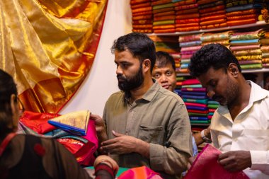 Yeni Delhi, Hindistan - 18 Kasım 2023: Ürünlerini satmak için Delhi ticaret fuarındaki bir tezgahta geleneksel giysili Hintli bir satıcının portresi.
