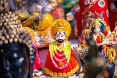 Handmade colourful idol of Lord Khatu Shyam on display at shop. Selective focus. clipart