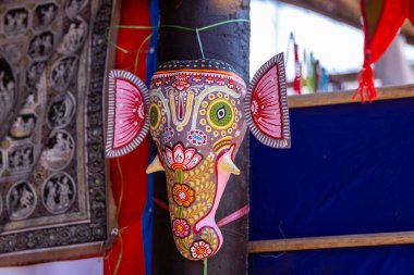 El yapımı rengarenk Lord Ganesh, arka planda asılı hatıra eşyası. Seçici odak.