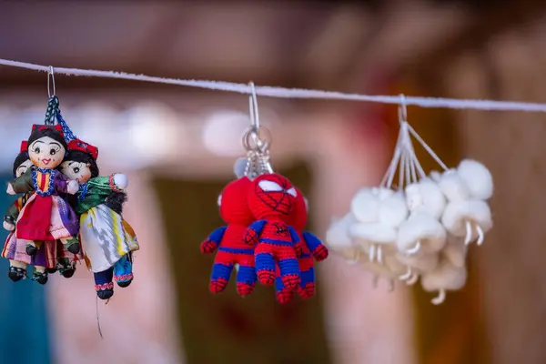 stock image Faridabad, Haryana, India - February 17 2024: Indian colorful handmade dolls and spiderman Puppets and Crafts products hanging at shop in fair. Products of kazakhstan. 