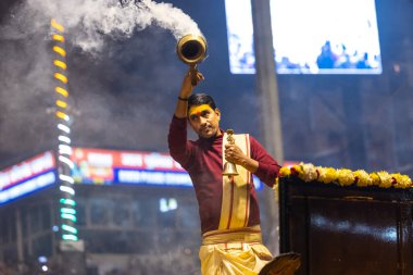 Varanasi, Uttar Pradesh, Hindistan - 18 Ocak 2024: Ganga aarti, Genç erkek rahibin portresi Dashashwamedh ghat 'ta kutsal nehir ganges akşam aarti gösterisi Hindu ayinleri ile geleneksel elbise.