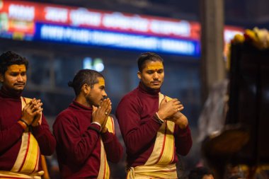 Varanasi, Uttar Pradesh, Hindistan - 18 Ocak 2024: Ganga aarti, bir grup genç erkek rahip Dashashwamedh ghat 'ta kutsal nehir çetelerini icra ediyor geleneksel Hint ayinleriyle geleneksel elbiseler içinde. 