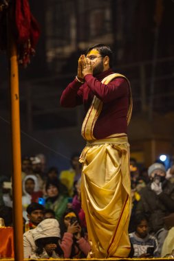 Varanasi, Uttar Pradesh, Hindistan - 18 Ocak 2024: Ganga aarti, Genç erkek rahibin portresi Dashashwamedh ghat 'ta kutsal nehir ganges akşam aarti gösterisi Hindu ayinleri ile geleneksel elbise.