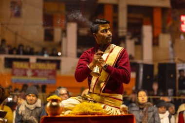 Varanasi, Uttar Pradesh, Hindistan - 18 Ocak 2024: Ganga aarti, Genç erkek rahibin portresi Dashashwamedh ghat 'ta kutsal nehir ganges akşam aarti gösterisi Hindu ayinleri ile geleneksel elbise.