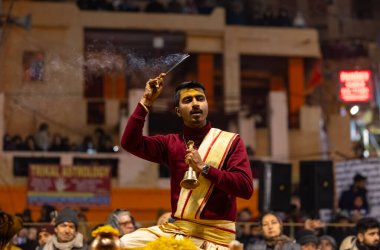 Varanasi, Uttar Pradesh, Hindistan - 18 Ocak 2024: Ganga aarti, Genç erkek rahibin portresi Dashashwamedh ghat 'ta kutsal nehir ganges akşam aarti gösterisi Hindu ayinleri ile geleneksel elbise.