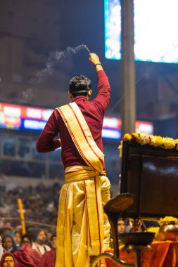 Varanasi, Uttar Pradesh, Hindistan - 18 Ocak 2024: Ganga aarti, Genç erkek rahibin portresi Dashashwamedh ghat 'ta kutsal nehir ganges akşam aarti gösterisi Hindu ayinleri ile geleneksel elbise.