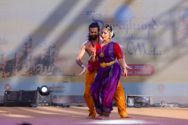 Faridabad, Haryana, Hindistan - 17 Şubat 2024: Güney Hintli erkek ve kadın sanatçı Surajkund sanatları fuarında klasik dans kuchipudi performansı sergiliyorlar.