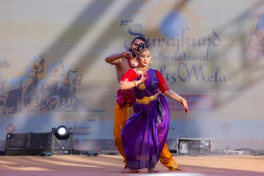 Faridabad, Haryana, Hindistan - 17 Şubat 2024: Güney Hintli erkek ve kadın sanatçı Surajkund sanatları fuarında klasik dans kuchipudi performansı sergiliyorlar.