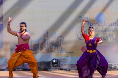Faridabad, Haryana, Hindistan - 17 Şubat 2024: Güney Hintli erkek ve kadın sanatçı Surajkund sanatları fuarında klasik dans kuchipudi performansı sergiliyorlar.