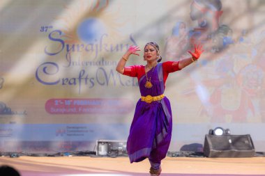Faridabad, Haryana, Hindistan - 17 Şubat 2024: Güney Hintli bir kadın sanatçının portresi geleneksel sari ve mücevher fuarında surajkund zanaat fuarında klasik dans kuchipudi gösterisi yapıyor.