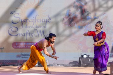 Faridabad, Haryana, Hindistan - 17 Şubat 2024: Güney Hintli erkek ve kadın sanatçı Surajkund sanatları fuarında klasik dans kuchipudi performansı sergiliyorlar.