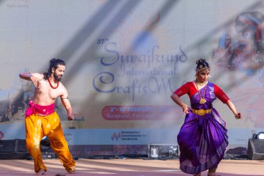 Faridabad, Haryana, Hindistan - 17 Şubat 2024: Güney Hintli erkek ve kadın sanatçı Surajkund sanatları fuarında klasik dans kuchipudi performansı sergiliyorlar.