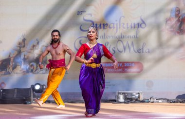 Faridabad, Haryana, Hindistan - 17 Şubat 2024: Güney Hintli erkek ve kadın sanatçı Surajkund sanatları fuarında klasik dans kuchipudi performansı sergiliyorlar.