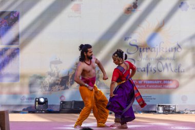 Faridabad, Haryana, Hindistan - 17 Şubat 2024: Güney Hintli erkek ve kadın sanatçı Surajkund sanatları fuarında klasik dans kuchipudi performansı sergiliyorlar.