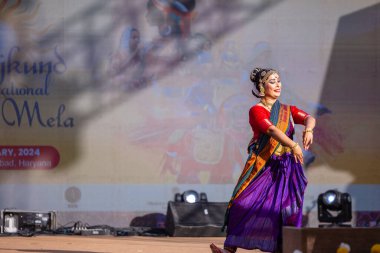 Faridabad, Haryana, Hindistan - 17 Şubat 2024: Güney Hintli bir kadın sanatçının portresi geleneksel sari ve mücevher fuarında surajkund zanaat fuarında klasik dans kuchipudi gösterisi yapıyor.
