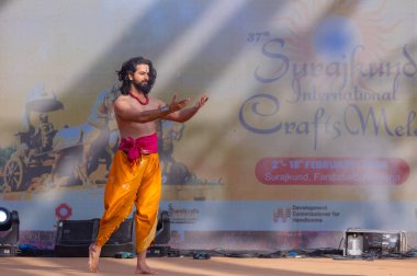 Faridabad, Haryana, Hindistan - 17 Şubat 2024: Güney Hintli erkek sanatçı surajkund sanatları fuarında klasik dans kuchipudi performansı sergiliyor. 