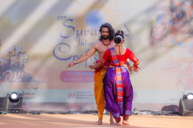Faridabad, Haryana, Hindistan - 17 Şubat 2024: Güney Hintli erkek ve kadın sanatçı Surajkund sanatları fuarında klasik dans kuchipudi performansı sergiliyorlar.