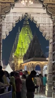 Varanasi, Uttar Pradesh, Hindistan - 22 Mart 2024: Geceleyin Varanasi 'deki Hindu tanrı baba vishwanath tapınağının mimari görünümü. Renkli ışıklar ve tapınak koridorunda kuyruğa girenler.  