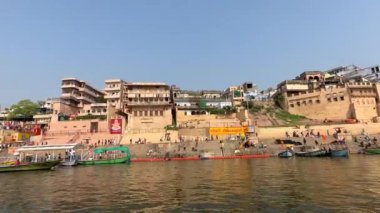 Varanasi, Uttar Pradesh, Hindistan - 22 Mart 2024: Antik binanın mimari görünümü ve kutsal nehir çetelerinin kıyısındaki tapınaklar ahşap bottan.