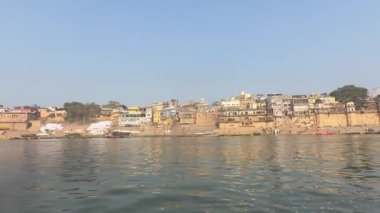 Varanasi, Uttar Pradesh, Hindistan - 22 Mart 2024: Antik binanın mimari görünümü ve kutsal nehir çetelerinin kıyısındaki tapınaklar ahşap bottan.