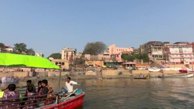 Varanasi, Uttar Pradesh, Hindistan - 22 Mart 2024: Antik binanın mimari görünümü ve kutsal nehir çetelerinin kıyısındaki tapınaklar ahşap bottan.