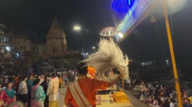 Varanasi, Uttar Pradesh, Hindistan - 22 Mart 2024: Ganga aarti, Genç erkek rahibin portresi Dashashwamedh ghat 'ta kutsal nehir ganges akşam aarti gösterisi Hindu ayinleri ile geleneksel elbise.