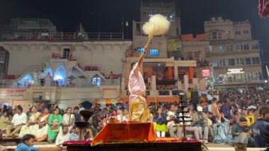 Varanasi, Uttar Pradesh, Hindistan - 20 Mart 2024: Ganga aarti, Genç erkek rahibin portresi Dashashwamedh ghat 'ta kutsal nehir ganges akşam aarti gösterisi Hindu ritüelleri ile geleneksel elbise.