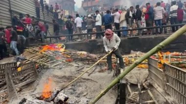 Varanasi, Uttar Pradesh, Hindistan - 22 Mart 2024: Mankarnika ghat üzerinde çalışan bir erkek işçinin portresi ölü bedenini yakma ghat 'ında Hindu ayinleriyle birlikte yaktı.