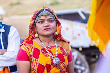 Faridabad, Haryana, India - February 17 2024: Portrait of an female artist from gujrat state in ethnic traditional dress participating in surajkund crafts fair to perform their cultural folk dance.