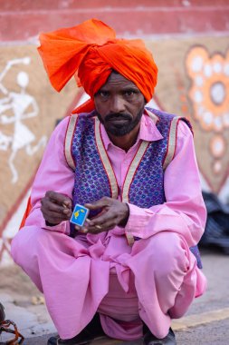 Faridabad, Haryana, India - February 17 2024: Portrait of male folk artist of haryana playing musical instrument during surajkund craft fair to entertain tourists. 