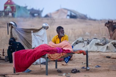 Pushkar, Rajasthan, Hindistan - 24 Kasım 2023: Pushkar Deve Fuarı 'nda kış sabahı dinlenen Hintli insanların portresi. 