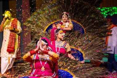 Gaziabad, Uttar Pradesh, Hindistan - 17 Mart 2024: Holi festivali sırasında renkli etnik kıyafetlerle phoolo ki holi çalan genç kadın sanatçıların portresi.