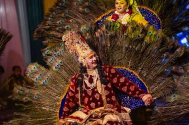 Gaziabad, Uttar Pradesh, Hindistan - 17 Mart 2024: Renkli etnik giysiler içinde Holi Festivali sırasında Phoolo ki holi 'yi Lord Krishna ve Tanrıça Radha olarak oynayan genç erkek ve kadın sanatçıların portresi.