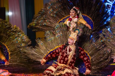 Gaziabad, Uttar Pradesh, Hindistan - 17 Mart 2024: Renkli etnik giysiler içinde Holi Festivali sırasında Phoolo ki holi 'yi Lord Krishna ve Tanrıça Radha olarak oynayan genç erkek ve kadın sanatçıların portresi.