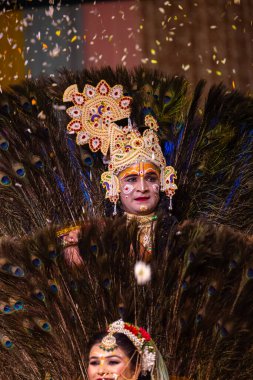 Gaziabad, Uttar Pradesh, Hindistan - 17 Mart 2024: Renkli etnik giysiler içinde Holi Festivali sırasında Phoolo ki holi 'yi Lord Krishna ve Tanrıça Radha olarak oynayan genç erkek ve kadın sanatçıların portresi.