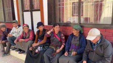 Sarnath, Uttar Pradesh, Hindistan - 21 Kasım 2022: Sarnath 'daki Budist tapınağında oturan Tibbet' li bir grup kadın ve erkek hakkında video.