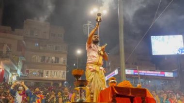 Varanasi, Uttar Pradesh, Hindistan - 21 Kasım 2022: Ganga aarti, Dashashwamedh ghat geleneksel elbise ve Hindu ayinleri ile kutsal nehir ganges akşam aarti performans genç rahip portresi.